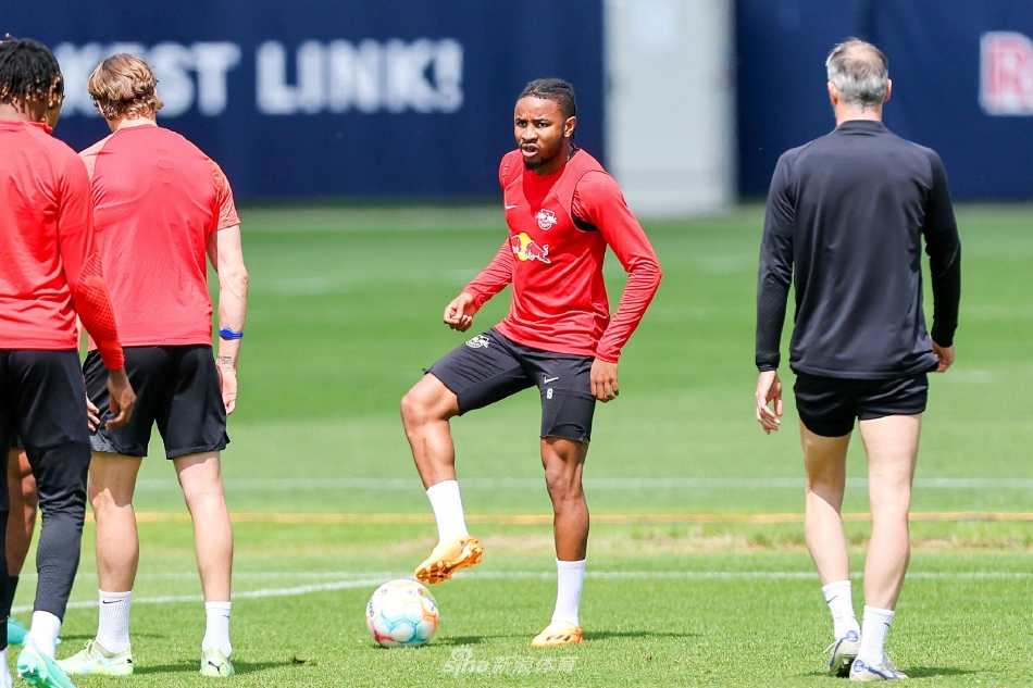 球员们围成一圈进行拉伸，夕阳将他们的身影拉长，汗水在金色光线下闪烁，彼此搭肩的动作透露出这支队伍紧密无间的团队精神