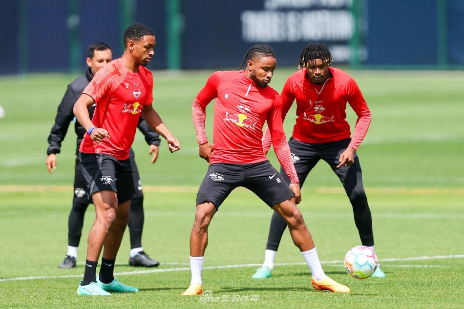 年轻球员在分组对抗中带球疾驰，他的身影与远处柏林奥林匹克体育场的宏伟轮廓重叠，象征着新生力量与足球历史的交汇瞬间