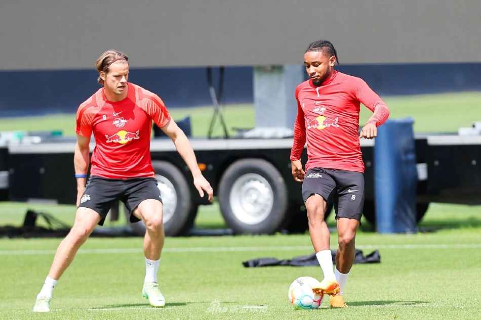 罗泽与教练组在场边紧密站在一起，众人目光如炬聚焦球场，手中的笔记本写满密密麻麻的注解，宛如运筹帷幄的战场指挥官