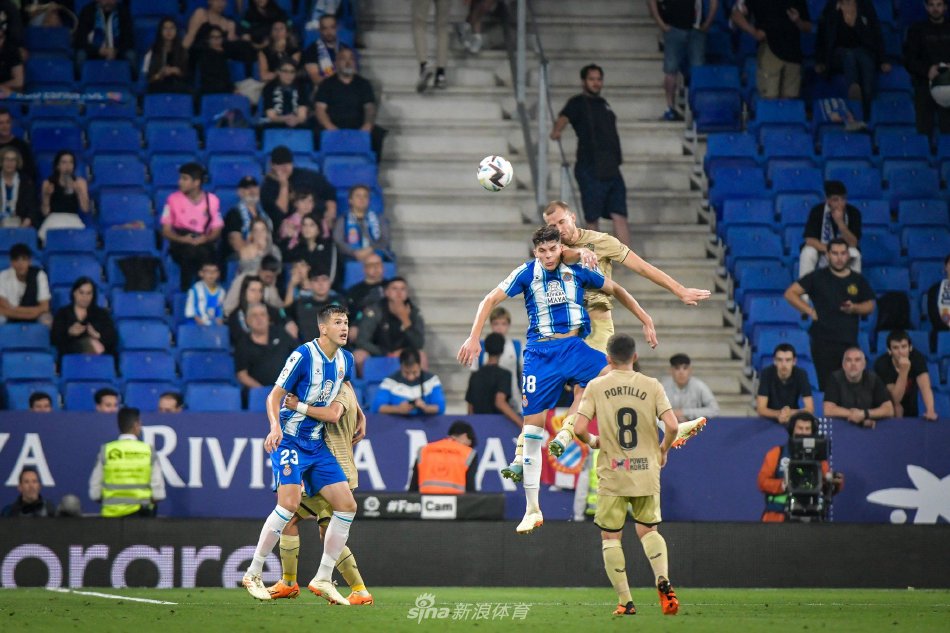 西班牙人队主教练在场边焦急指挥，背景是坐满主场球迷的壮观看台