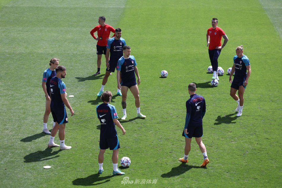 主教练达利奇双臂环抱，目光如炬地注视着训练场，眉宇间凝聚着对战术的深思熟虑。