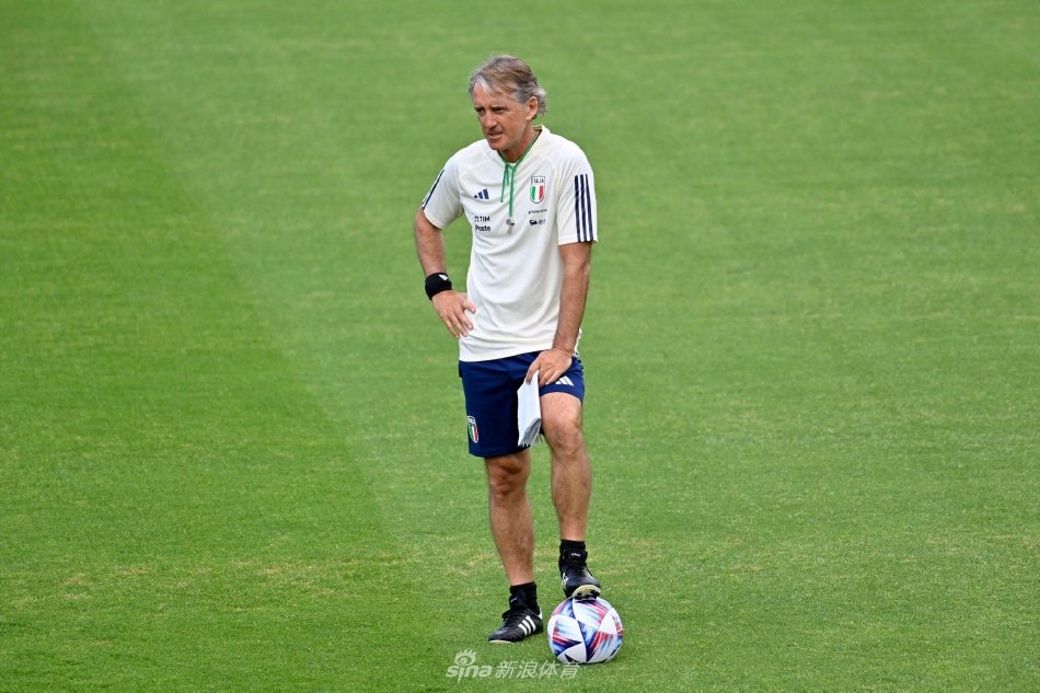 曼奇尼教练与助理教练在场边专注讨论战术，手中战术板勾勒出进攻路线