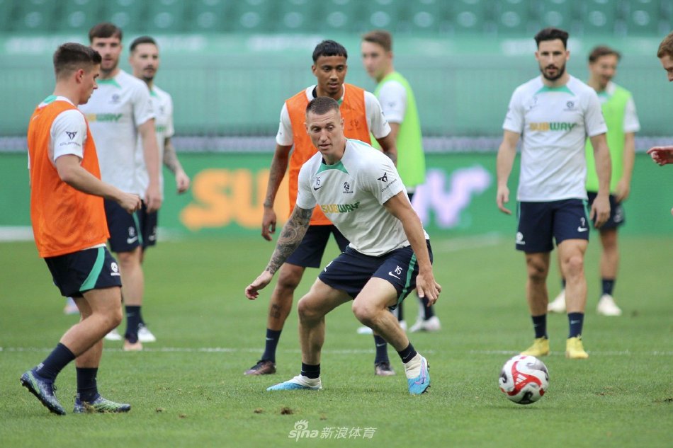 两名球员在训练中友好击掌，相视一笑，展现了竞技体育中互助与尊重的精神。