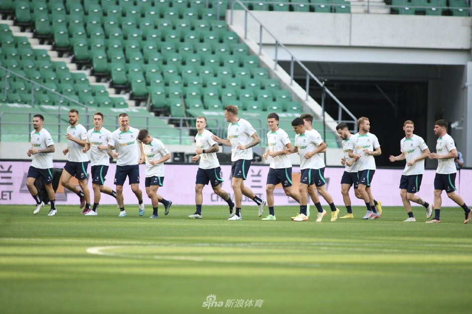 球员们围成一圈进行拉伸训练，在落日余晖下身影被拉长，团队氛围显得既专注又融洽。