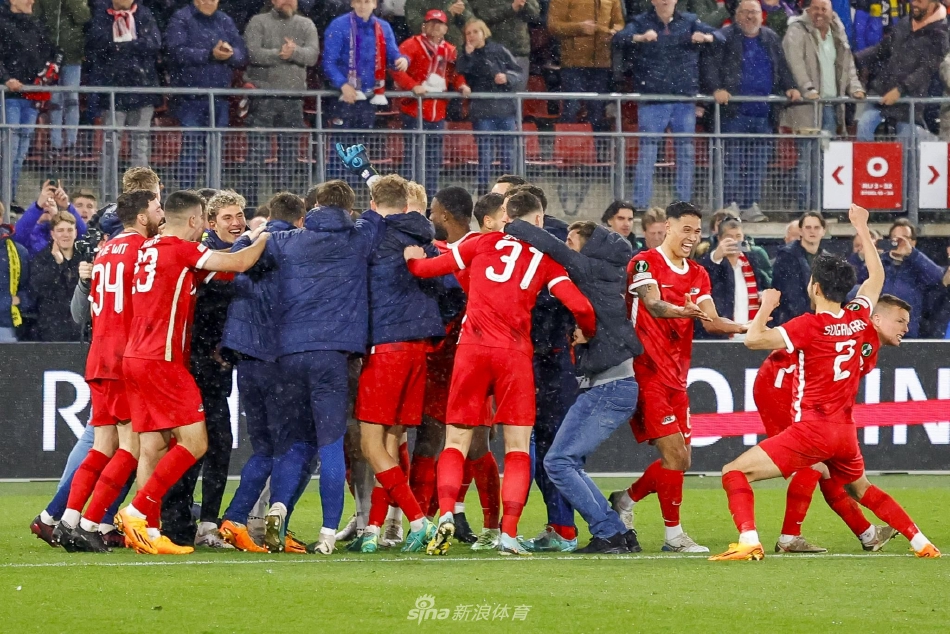 帕夫利季斯张开双臂奔跑庆祝第二个进球，队友从后方激动地跃起试图与他相拥。