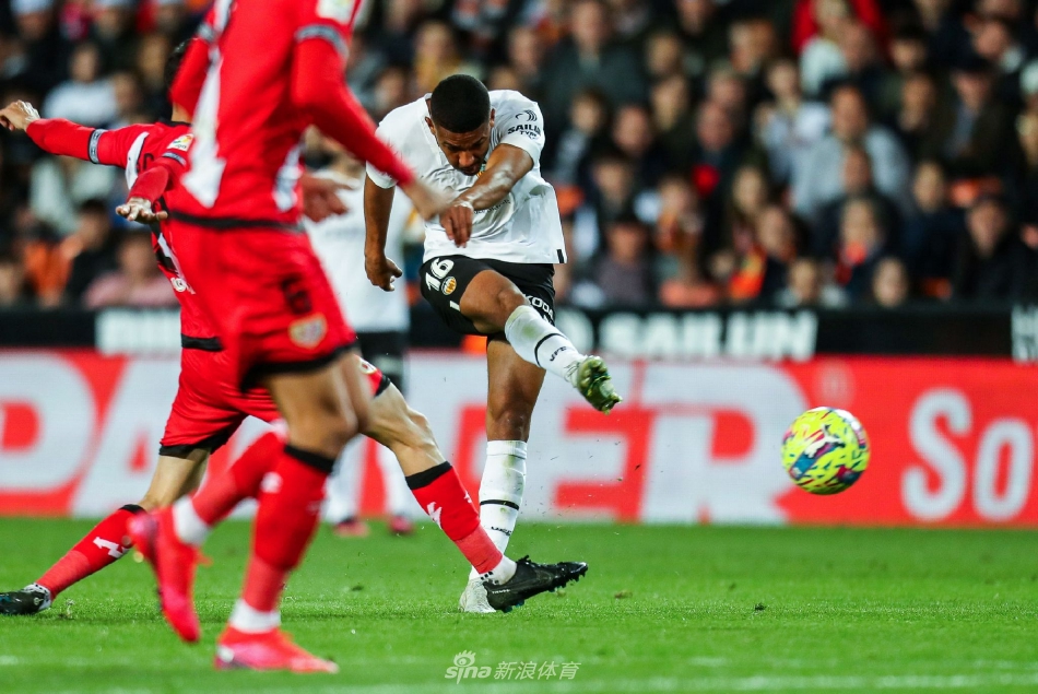 巴伦西亚球员主罚任意球瞬间，人墙高高跃起，皮球划出一道弧线越过人墙飞向球门。