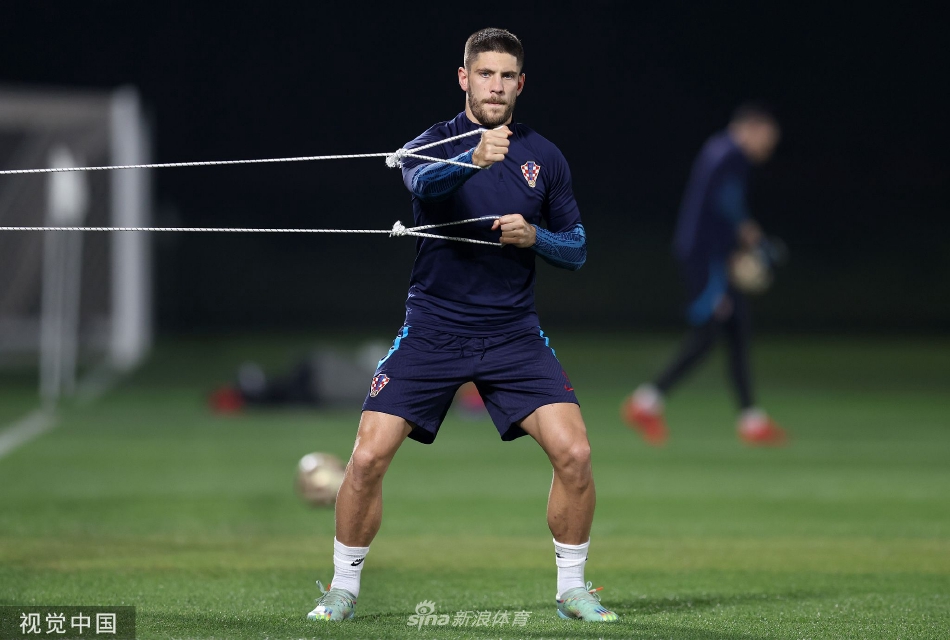 训练间隙球员进行拉伸放松，背景中哈里发国际体育场静静矗立