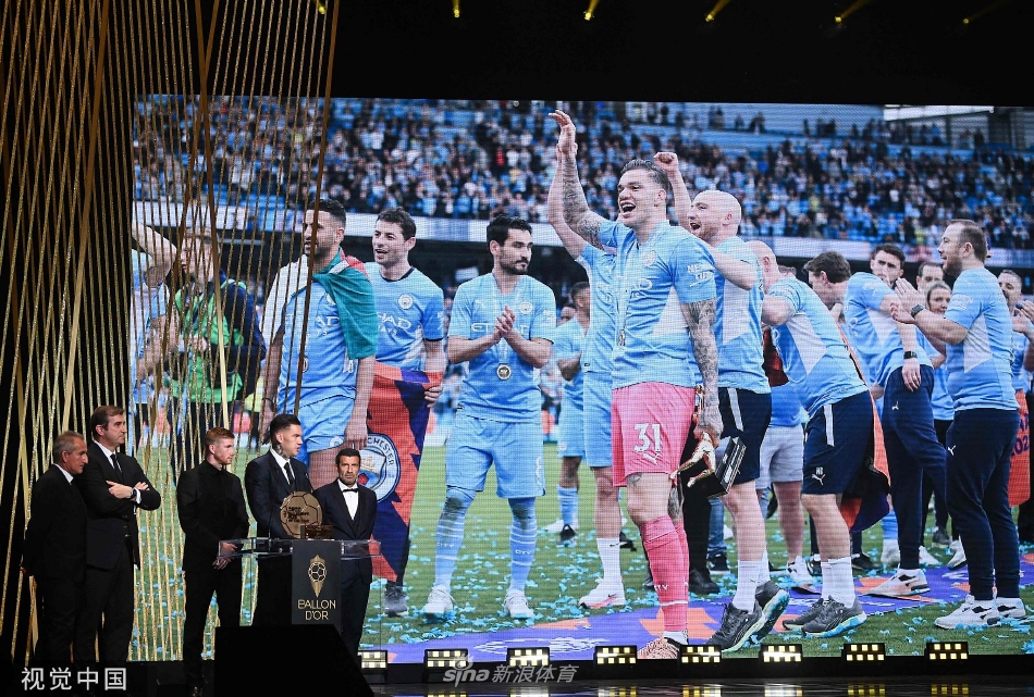 曼城俱乐部代表在颁奖台上高举年度最佳俱乐部奖杯，背景是璀璨的星空幕布，寓意着蓝月军团的荣耀时刻照亮足坛。