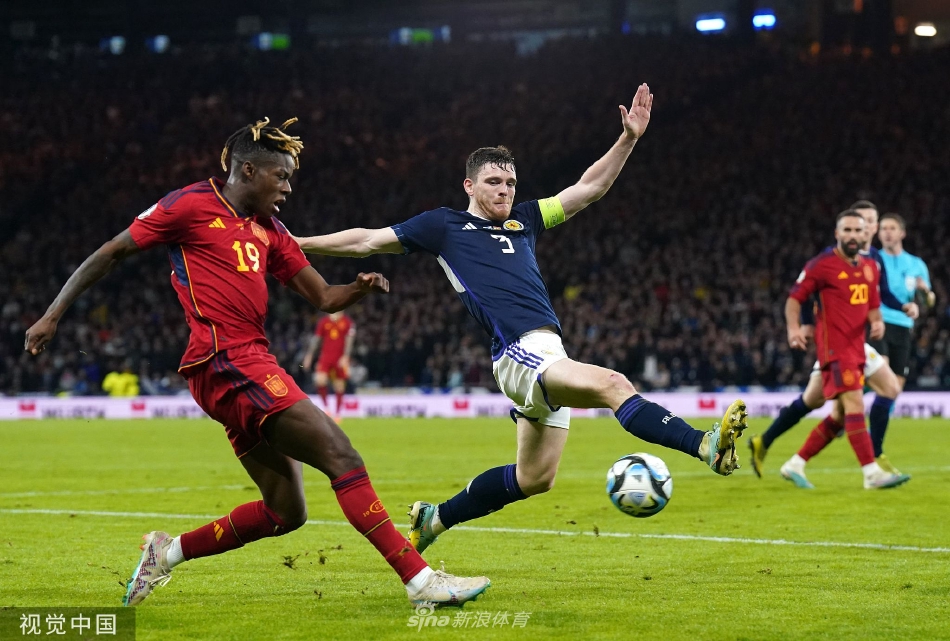 西班牙球员赛后神情落寞，与背景中狂欢的苏格兰球迷形成鲜明对比。