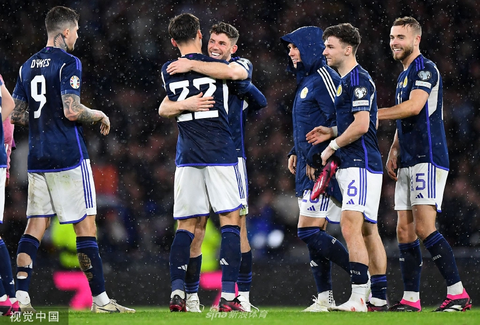 苏格兰全队簇拥在一起激情庆祝，红色球衣汇成一片欢腾的海洋。