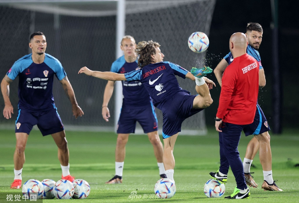 中场大师的足尖芭蕾：莫德里奇面带专注的微笑，正用左脚轻巧地将足球颠起，球仿佛粘在他的脚背上，背景中虚化的队友与看台，衬托出他绝对的专注与掌控力。