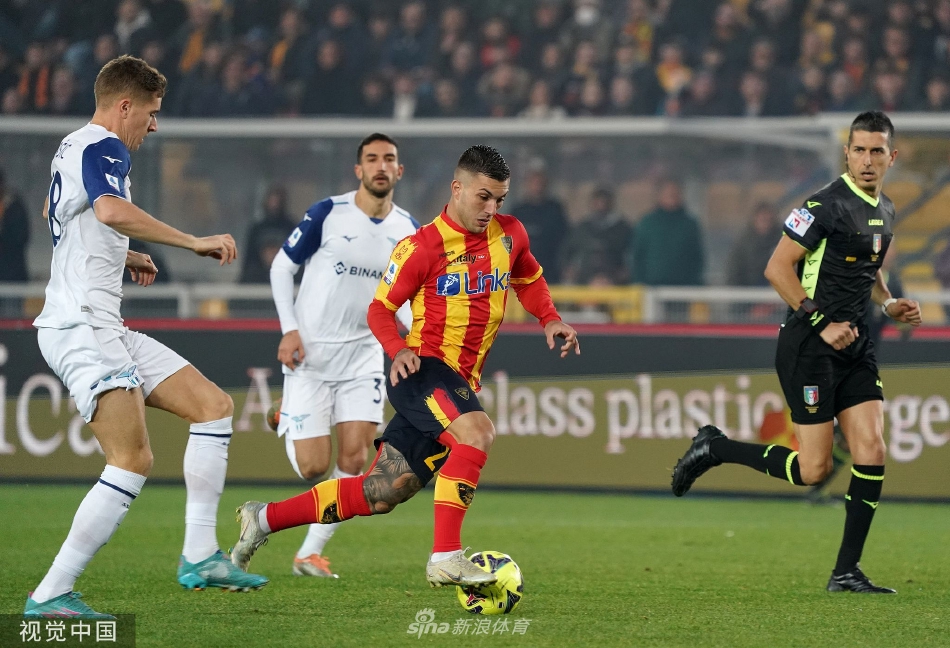 比赛中断期间，主裁判与双方队长围在一起严肃沟通，背景看台上是情绪激动的人群