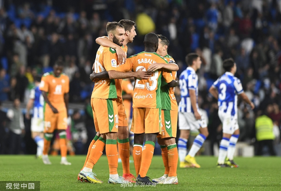 贝蒂斯进球功臣张开双臂在草地上滑翔庆祝，身后是呆若木鸡的主队门将与沮丧的防守球员