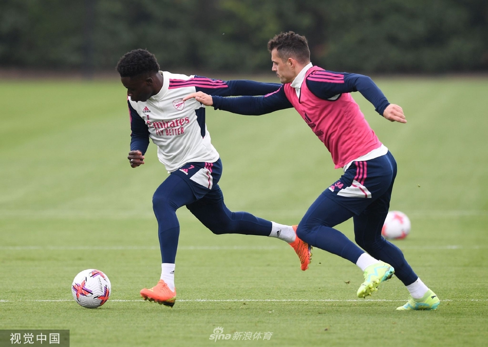 主教练阿尔特塔站在场地中央，正全神贯注地向围绕他的队员们布置战术，球员们的目光聚焦，充满了对胜利的渴望。