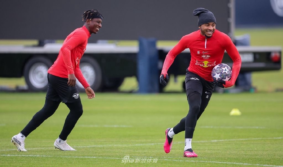 主教练与核心球员在训练场边神情专注地讨论战术，身后的球场映衬着他们决战前的深思熟虑。