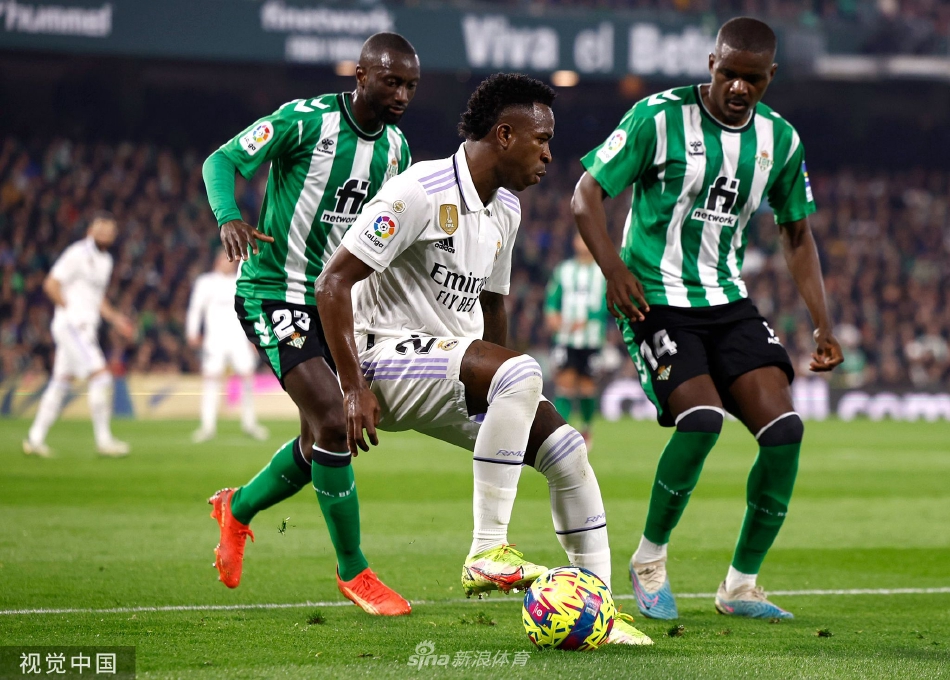 看台上皇家贝蒂斯的小球迷身穿绿色球衣，挥舞围巾，眼神中充满对主队的热爱与骄傲。