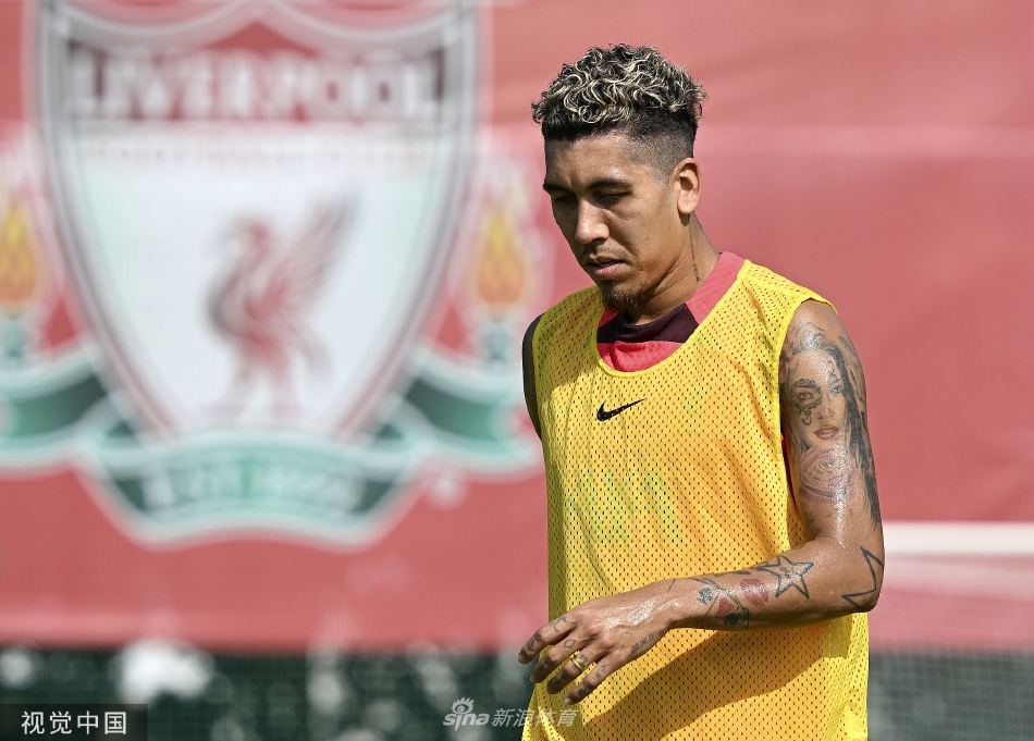 利物浦球员在迪拜训练场上积极拼抢，阳光洒在绿色草皮与红色球衣上，构成一幅充满活力的画面。