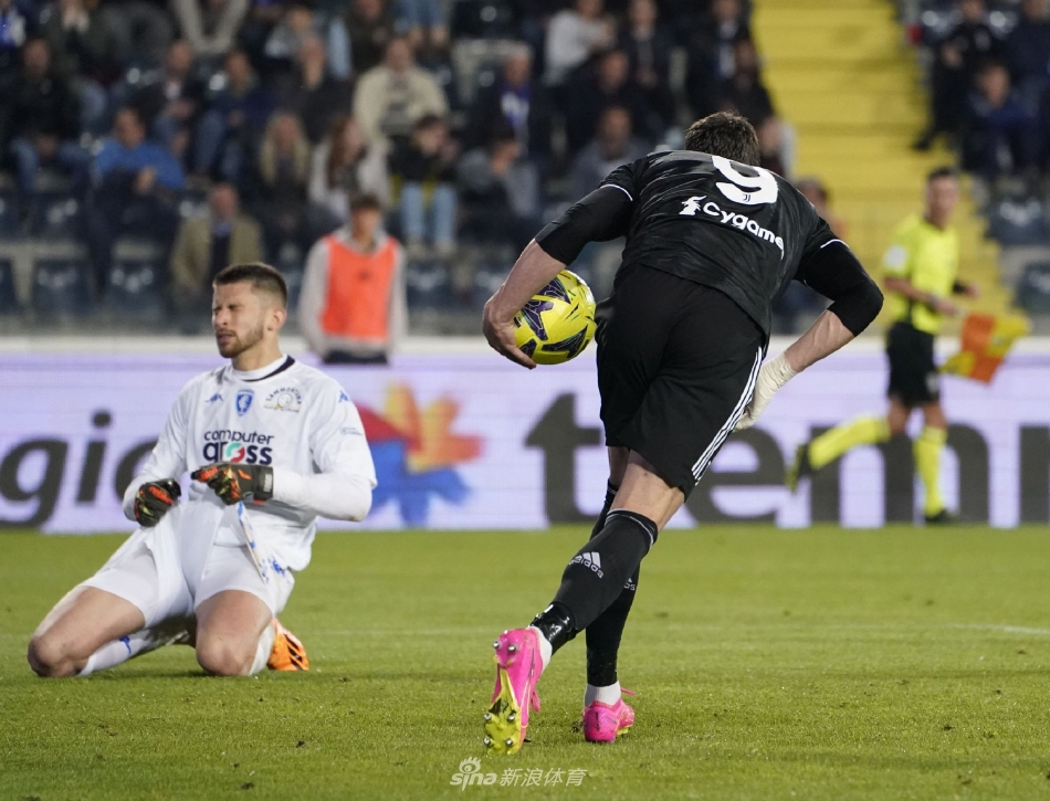 尤文图斯后卫在失球后跪地掩面，身旁恩波利球员相拥欢庆，黑白条纹衫在夜幕下格外落寞