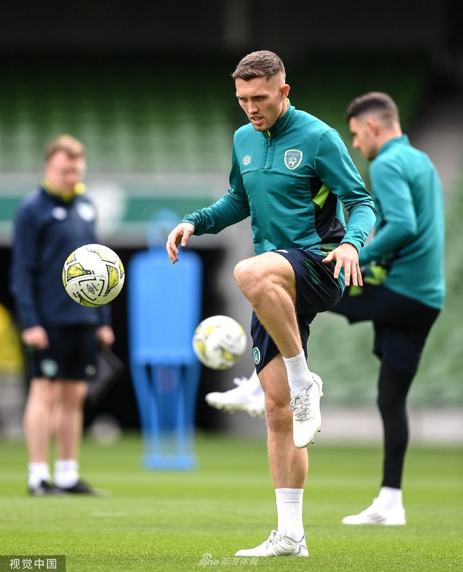 训练结束后球员们围成一圈互相鼓舞，绿色的队服在阳光下格外醒目，展现出团队坚韧不拔的凝聚力。