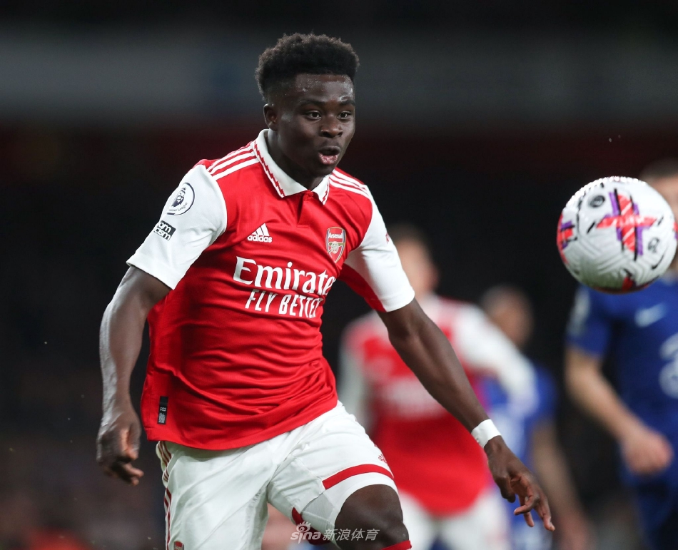 萨卡与家人或经纪人一同分享续约喜悦的温馨时刻，背景是俱乐部主场或标志物，氛围幸福而感人