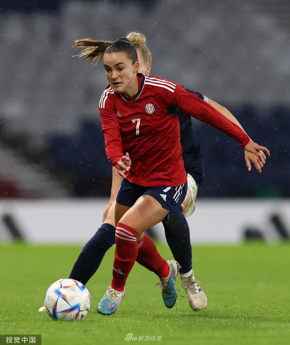 苏格兰队球员积极拼抢，一名球员正飞身铲断，草地碎屑飞溅，展现了比赛的高强度和对抗性。