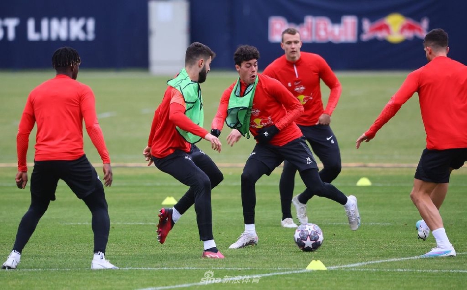 训练间隙，球员们围成一圈听取教练布置，阳光洒在肩头，勾勒出一幅为共同目标而团结奋进的生动画面。