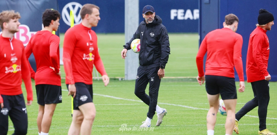 训练结束后，球员们围成一圈聆听主教练的总结讲话，夕阳余晖为他们镀上一层金边，团队的凝聚力在此刻无声升华。