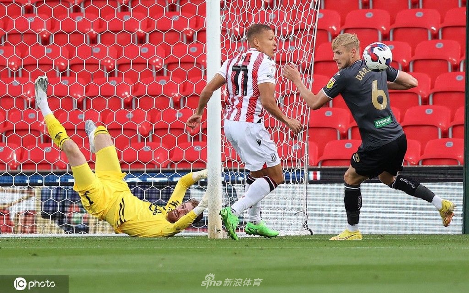 斯托克城球员高高跃起，力压防守队员奋力头球攻门，身体在空中舒展成一道充满力量感的曲线。