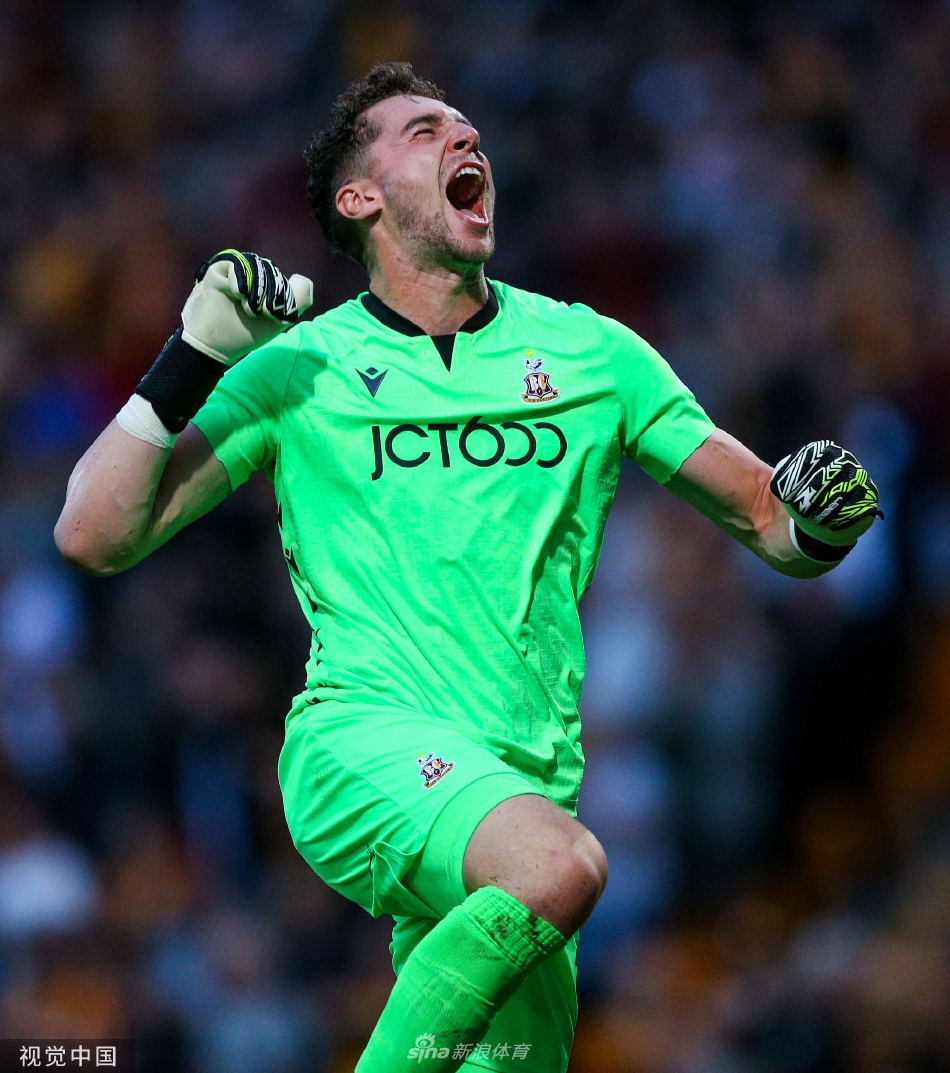 布拉德福德球员在丢失关键球后跪地抱头，神情极度沮丧，身旁的对手正快速跑过准备开球，光影对比强烈，凸显了足球世界的瞬间悲喜。