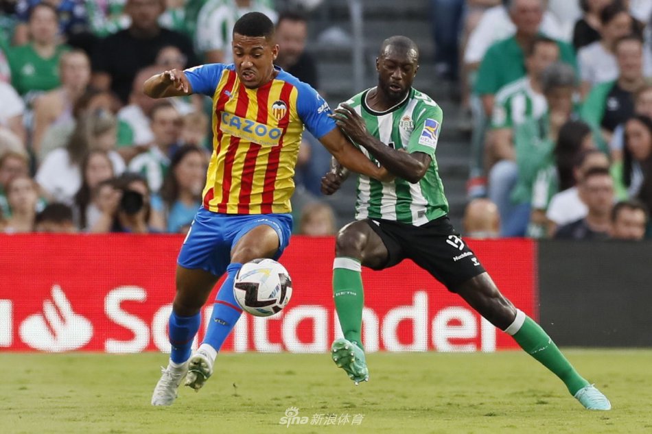 贝蒂斯前锋伊格莱西亚斯带球突破，面对两名防守队员的夹击，身体对抗激烈，寸土不让。