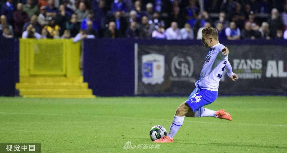 点球大战中，林肯城门将飞身扑救的瞬间，表情专注而坚定，巴罗主罚球员则面露遗憾。