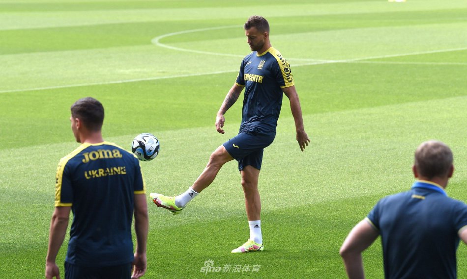 两名乌克兰队后卫在绿茵场上紧密协作，进行一对一防守演练，肌肉线条展现出职业运动员的力量感。