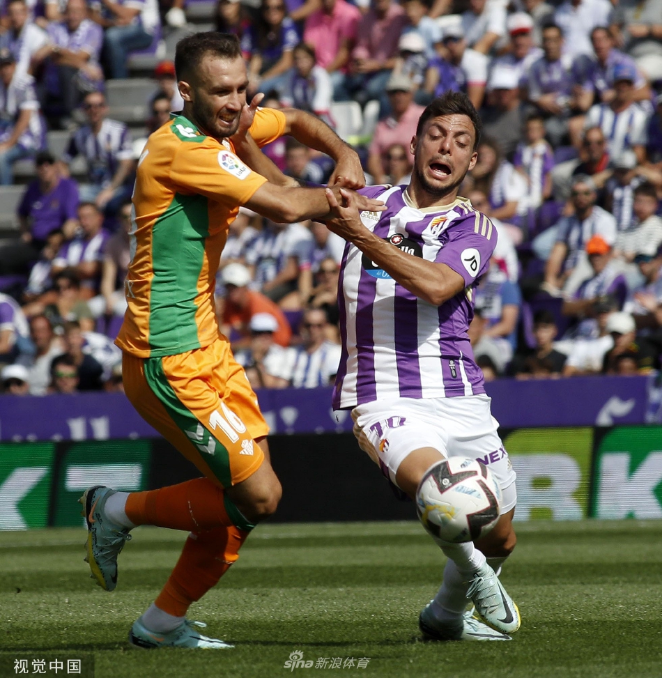 激烈对抗：双方中场球员为争夺球权展开贴身肉搏，贝蒂斯球员卡瓦略与巴拉多利德球员梅萨纠缠在一起，展现了比赛的高强度身体对抗。