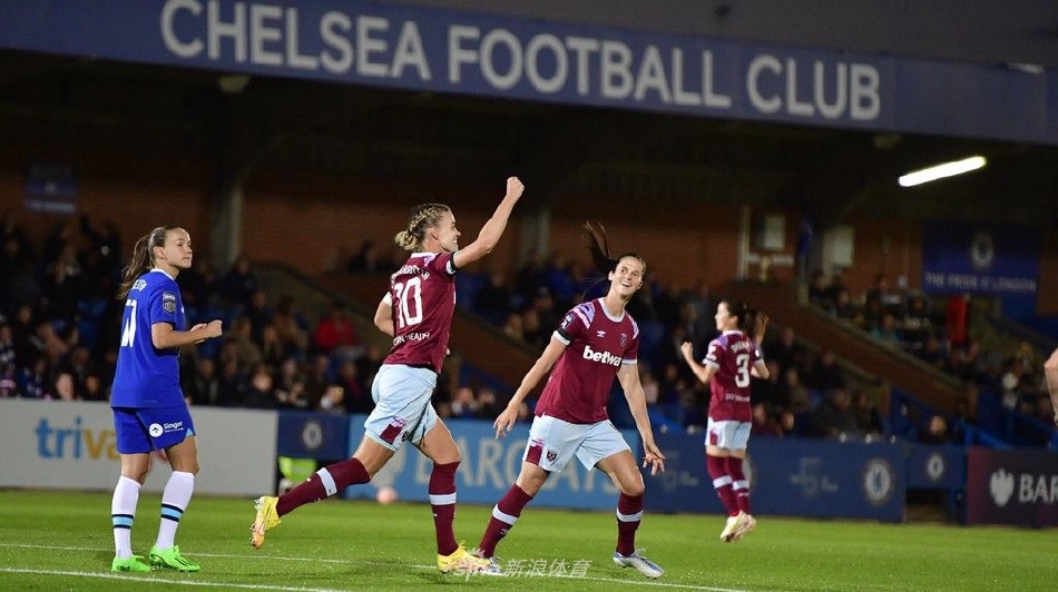 切尔西球员弗兰·柯比进球后张开双臂奔跑庆祝，脸上洋溢着灿烂笑容，背景是绿色草坪和追赶的队友。