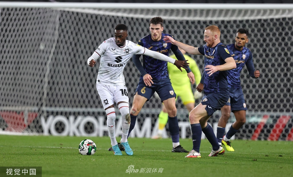 米尔顿凯恩斯球员激情庆祝进球，他张开双臂奔向角旗区，身后是欢呼雀跃的队友