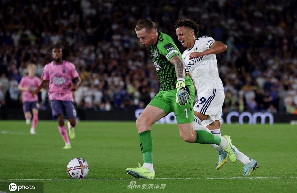 利兹联球员西尼斯特拉进球后张开双臂奔向角旗区庆祝，队友从后方激动跃起