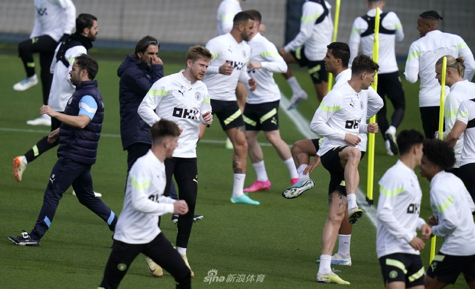 主帅瓜迪奥拉在场边凝神沉思，手中战术板记录着精密部署，仿佛一位运筹帷幄的将军正在构思决胜千里的战略。