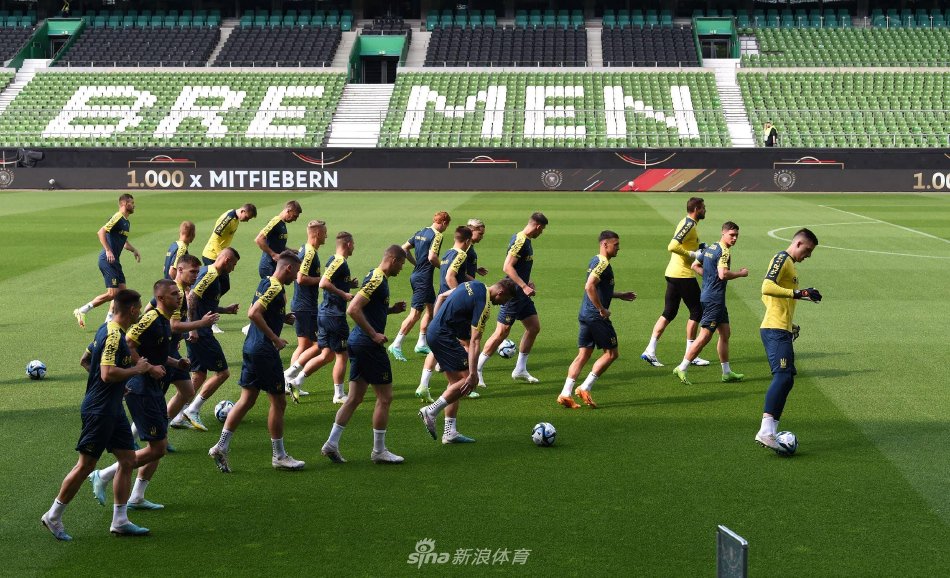 不莱梅训练场上，乌克兰队球员围成一圈进行高强度抢球训练，阳光下的身影展现出专注与活力。