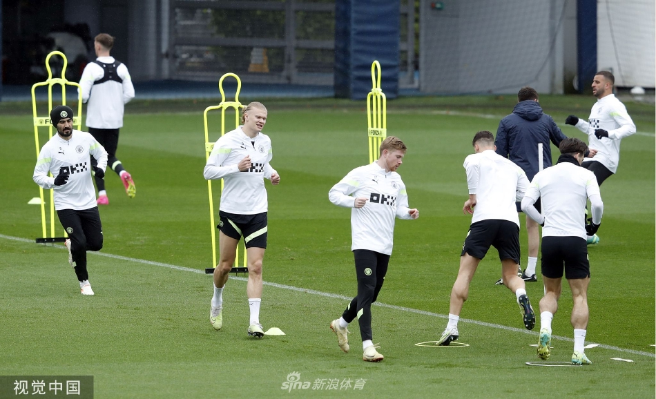 埃尔林·哈兰德在训练中高高跃起，力压防守队友争顶头球，展现出其标志性的强大制空能力和强烈的进球欲望。