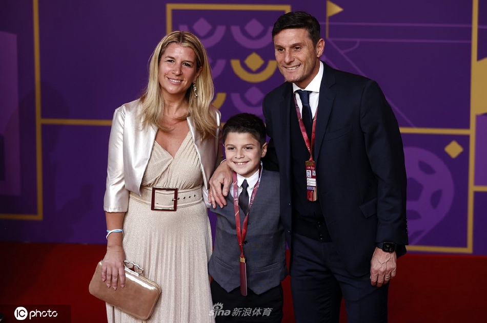 萨内蒂全家福定格幸福瞬间，孩子们笑容灿烂依偎在父母身旁，背景是璀璨的舞台灯光，构成一幅充满爱与荣耀的温馨画面。