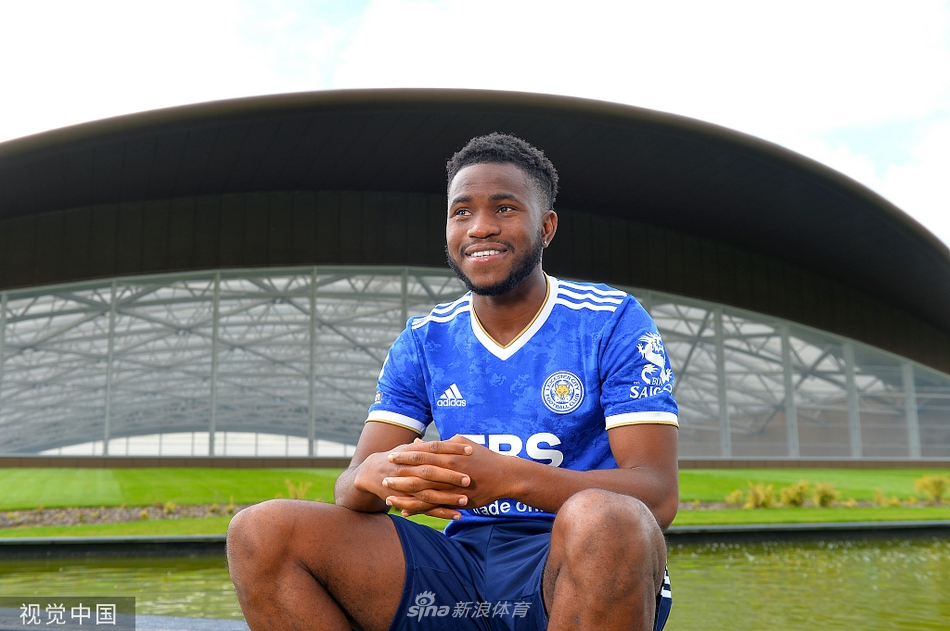 加盟仪式上，卢克曼手持莱斯特城围巾站在看台前，背后的蓝色座椅静静等待着新赛季为他欢呼的球迷们。