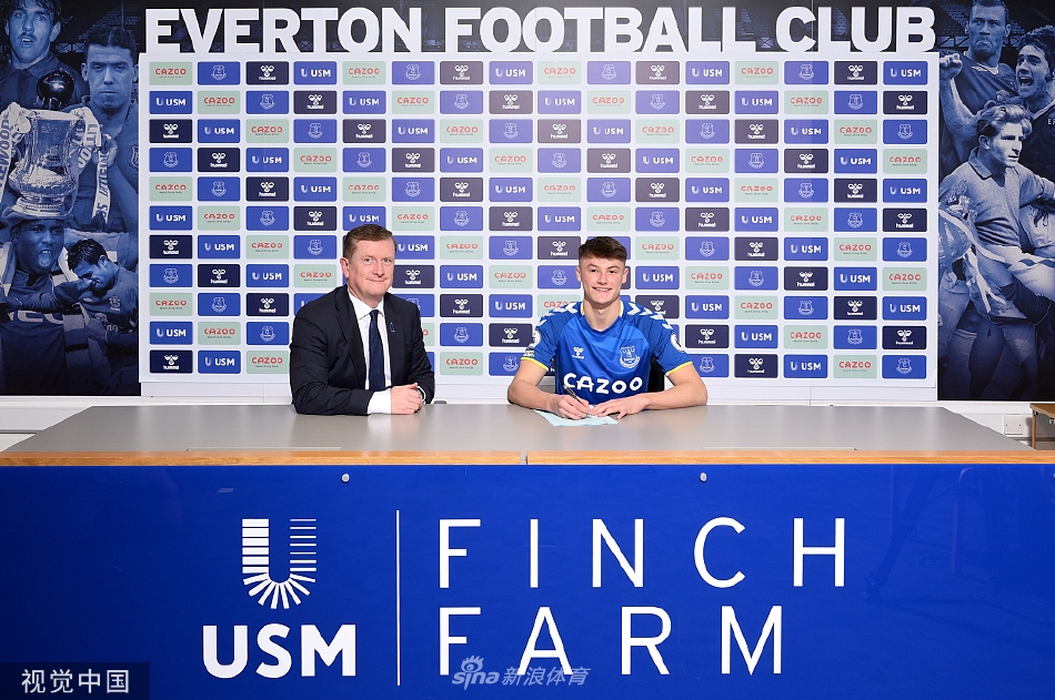 帕特森面带微笑，正与身旁的俱乐部工作人员轻松交流，展现了其迅速融入新团队的良好心态与亲和力。