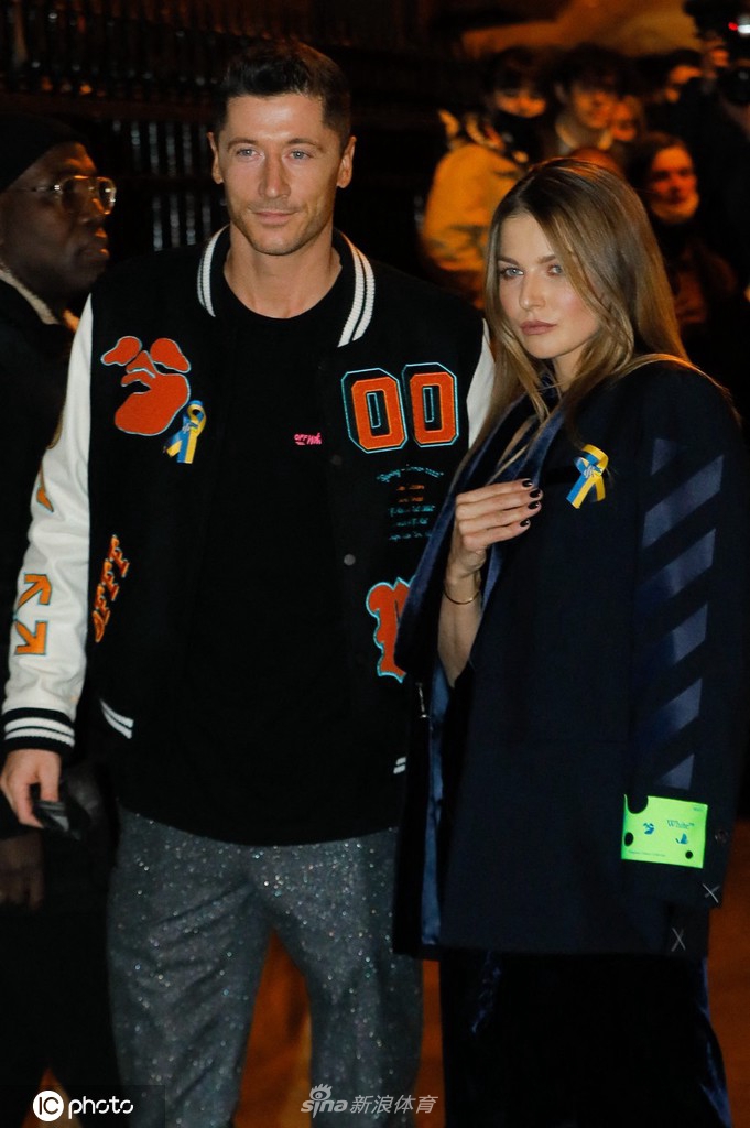 夫妻二人坐在秀场前排，莱万握起安娜的手轻轻放在膝上，安娜则回以充满爱意的凝视，细节之处尽显温情。