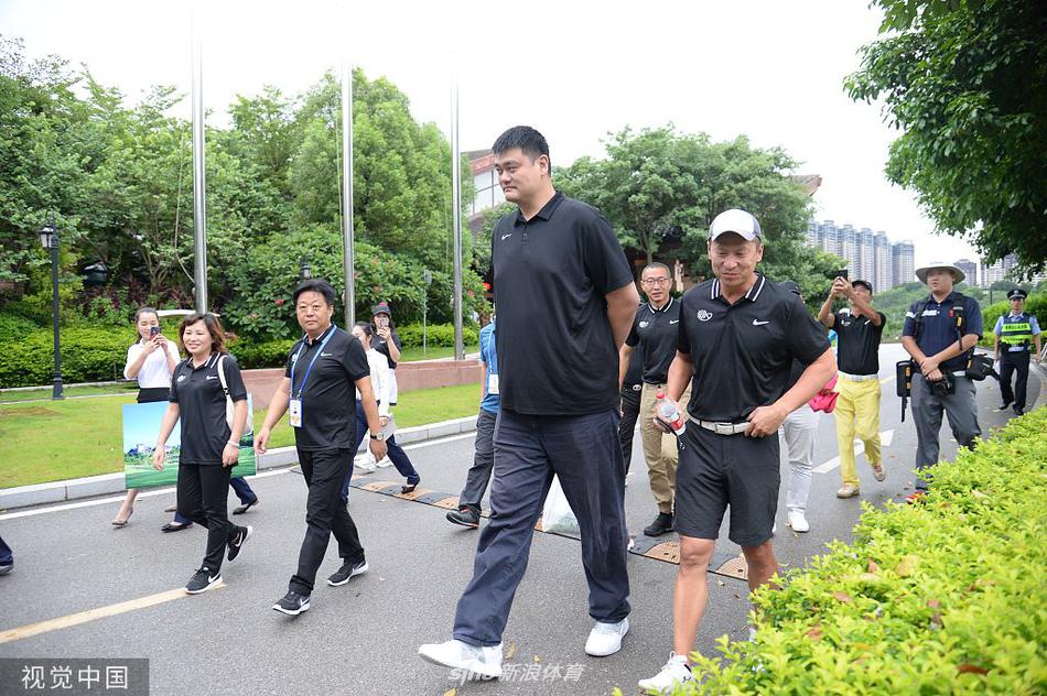 果岭一隅,姚明认真观察着草皮的纹路和坡度,准备推杆,身后是连绵的绿色球道和南宁夏日的葱茏植被,构成一幅动静结合的画面