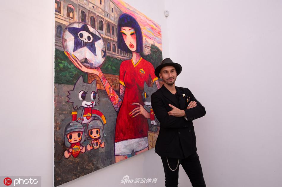 展览现场一角，背景是仿古罗马建筑的拱门装饰，一位模特身穿莱诺设计的拼接长裙伫立其中，面料的流动感与石料的厚重形成有趣对比。