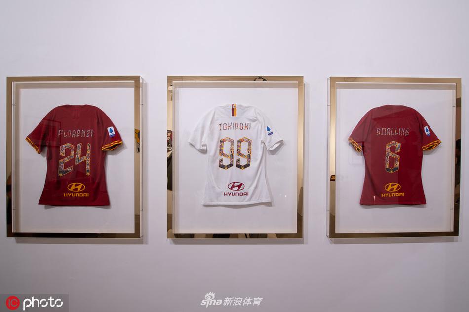 特写展示一件印有罗马地图图案的oversize外套，精细的街道线条与鲜艳的潮牌色彩结合，旁边是模特人台上的解构式长袍，充满设计感。