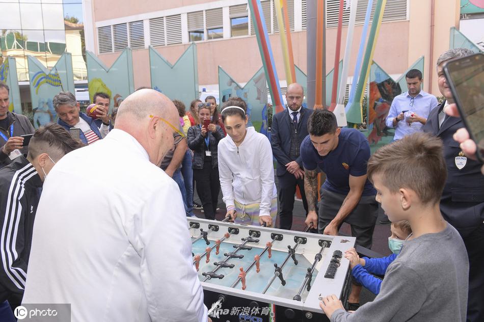 佩罗蒂微微前倾身体，全神贯注地倾听一位坐在病床上穿着病号服的小球迷说话，眼神中满是关切，这一刻他不是球星，而是一位值得信赖的兄长。