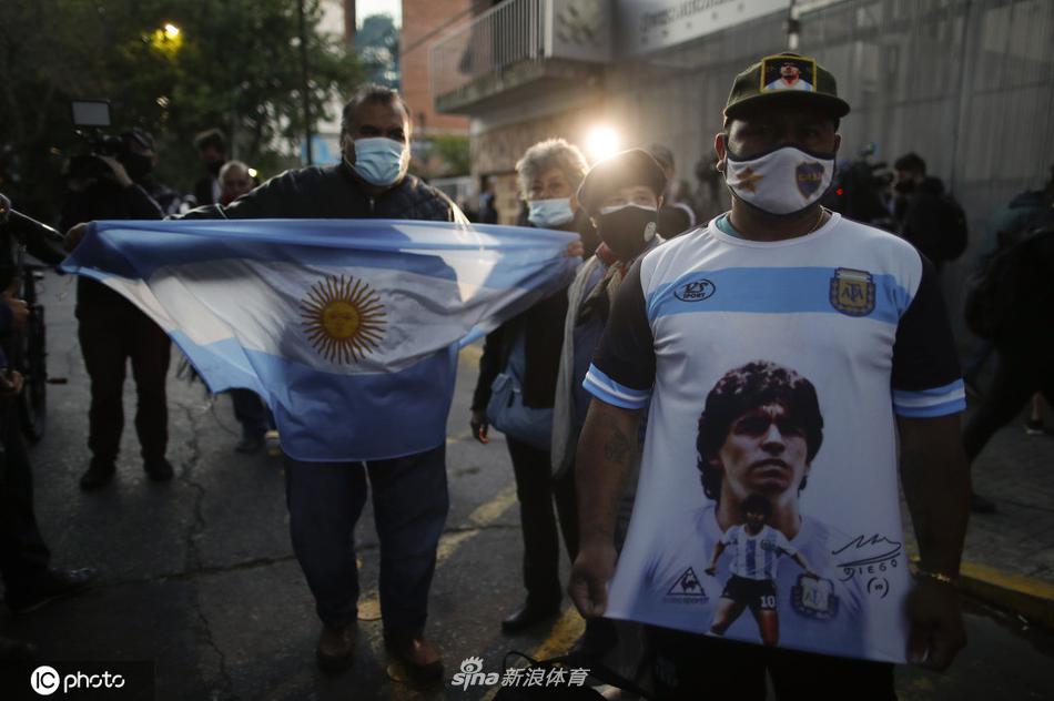 神情肃穆的阿根廷球迷们紧贴在医院外的围栏旁，目光穿过夜色，久久凝视着马拉多纳所在的住院楼方向。