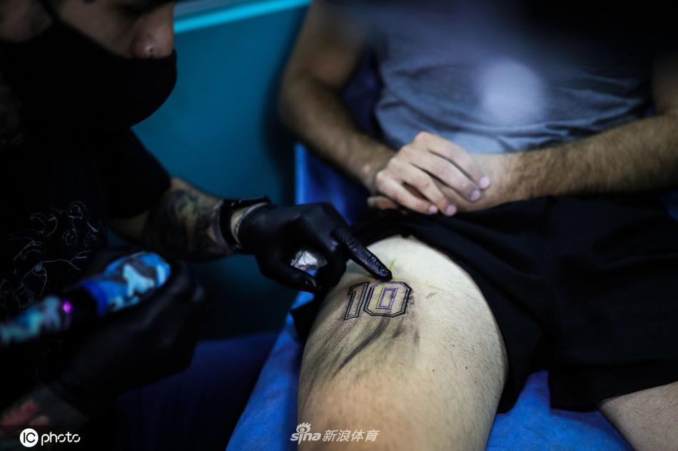 一位球迷掀起上衣，展示着后腰上新刻的马拉多纳头像，画中的马拉多纳目光坚毅，仿佛依然在为阿根廷足球的未来呐喊，蓝黑色的墨水与肤色融为一体。