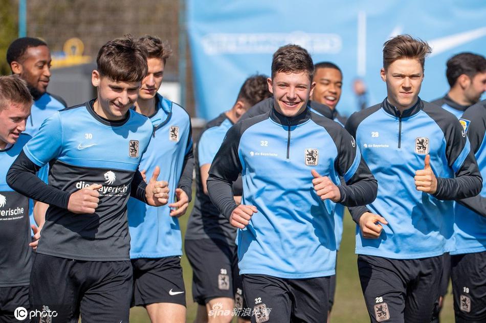 在绿茵场上，慕尼黑1860的球员们正在进行高强度的分组对抗，一名球员正全神贯注地盘带过人，汗水在阳光下闪闪发光。